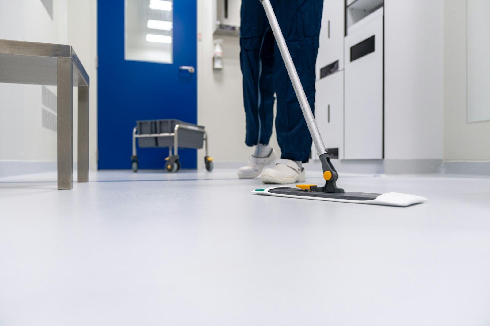A technician cleaning a sterile clinical floor in a healthcare facility